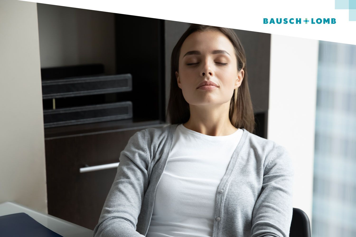 Dziewczyna siedząca przy biurku z zamkniętymi oczami, wykonuje ćwiczenia oczu